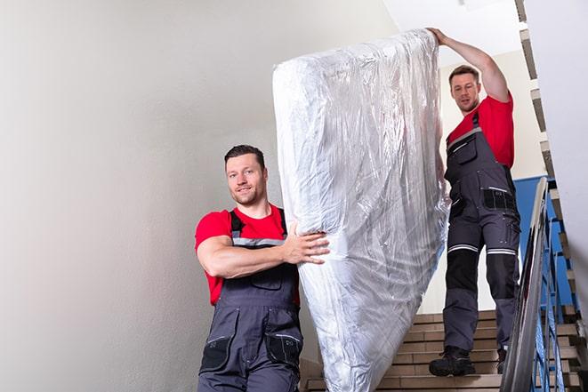 transporting a box spring out of a residential building in Delhi, CA